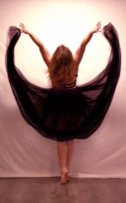 Danseuse avec tule noir réalisant un relevé